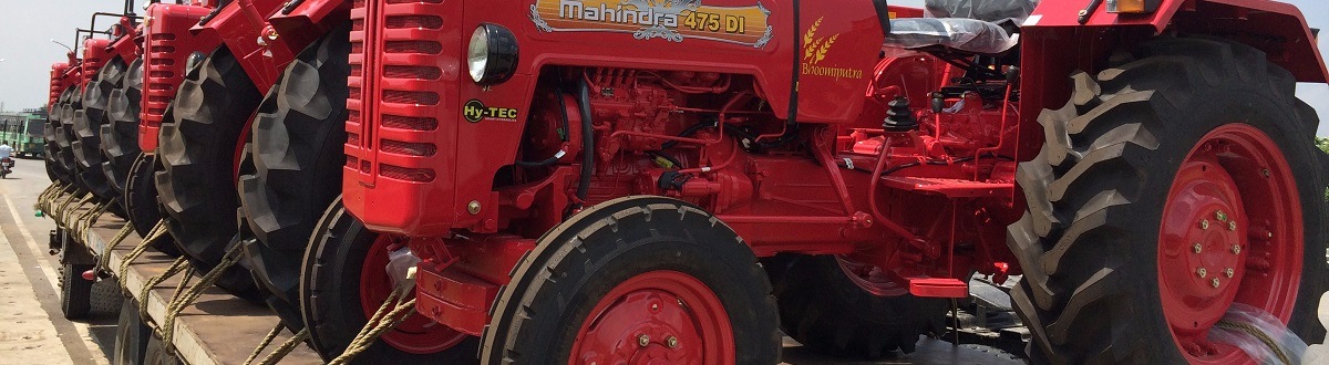 A row of red Mahindra® tractors parked on a truck